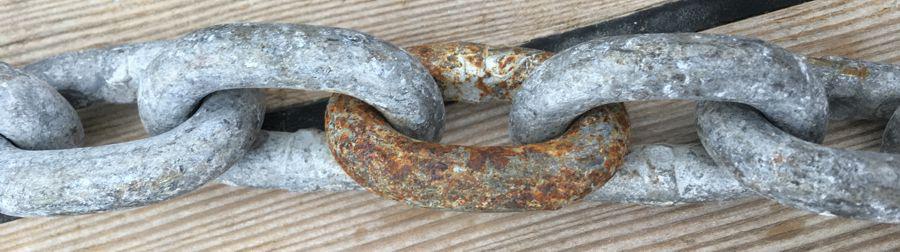 Rusty link in galvanised chain